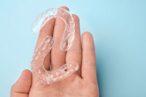 Clear aligners resting on palm of a hand